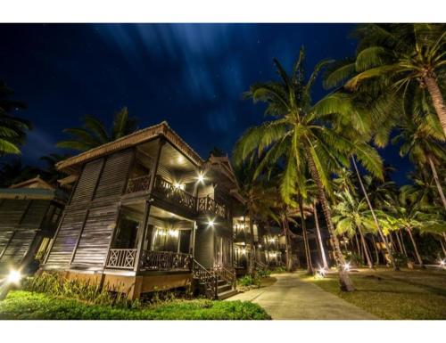 热浪岛塔拉斯海滩Spa度假酒店的棕榈树的木屋