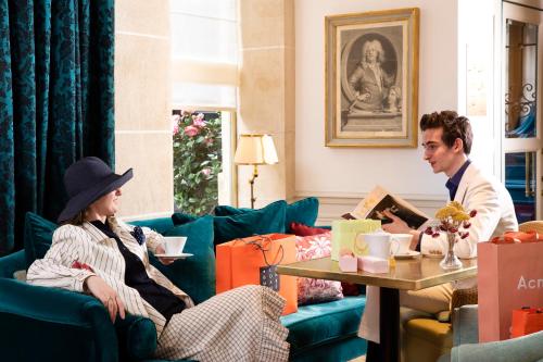巴黎Odeon Hotel by Malone的坐在客厅的男人和女人