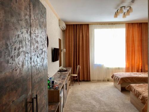 阿克托比Flamingo的酒店客房配有一张床、一张书桌和一台电视。