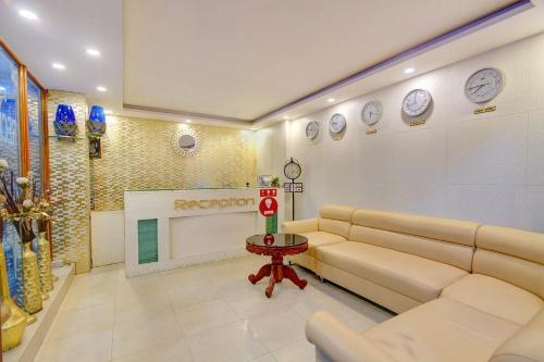 迈索尔Aishwarya Le Royal的客厅配有沙发和墙上的时钟