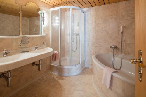 采尔马特欧陆酒店的带淋浴、盥洗盆和浴缸的浴室