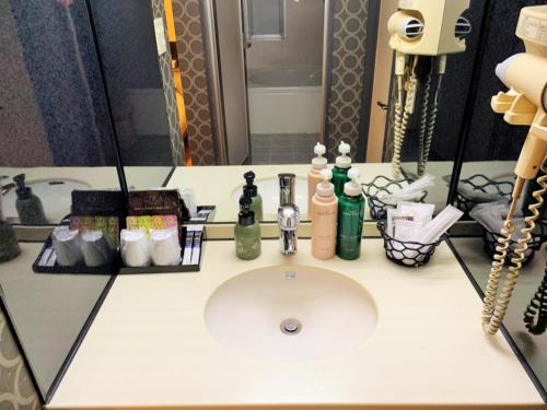 东京Hotel NewMie (Adult Only)的浴室的柜台在镜子前设有水槽