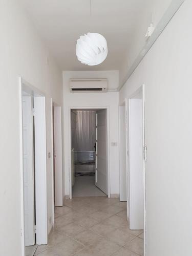 卡瓦利诺CASAWHITE的一条带白色墙壁和灯具的走廊