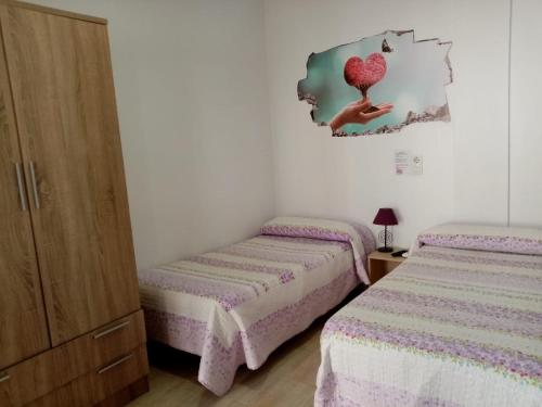 奇克拉纳－德拉弗龙特拉拉坎帕旅馆的卧室配有两张床,墙上有心