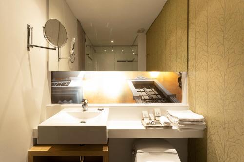 波哥大BH比森特纳里奥酒店的一间带水槽和镜子的浴室