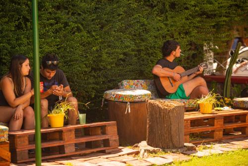 维拉卡洛斯帕兹Blau Hostel的一群坐在长椅上弹吉他的人