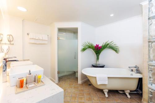 格罗斯岛可可棕榈的白色的浴室设有浴缸和水槽。