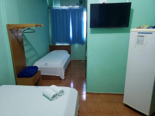 吉巴拉那Hotel Chalé Ji-Parana的小房间设有两张床和电视
