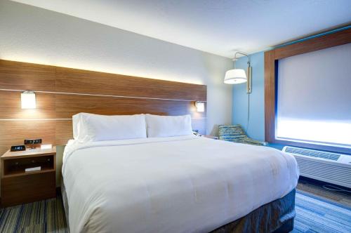北普拉特Holiday Inn Express & Suites North Platte, an IHG Hotel的一张大白色床,位于酒店带窗户的房间内
