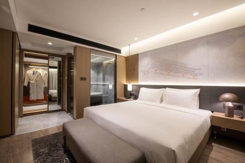 西安西安钟楼诺富特酒店的一间带白色大床的卧室和更衣室