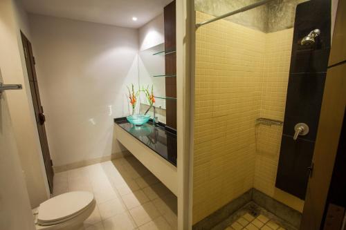 清迈桑宁静旅馆的带淋浴、卫生间和玻璃台面的浴室