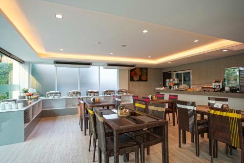 清迈Nantra Chiangmai Riverfront Hotel的一间带桌椅的餐厅和一间厨房