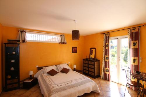 Le SolerMas Uranie的卧室拥有黄色的墙壁,设有一张床和窗户。