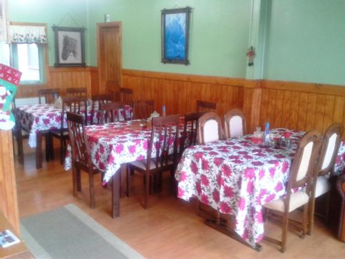 纳塔列斯港埃尔林孔旅馆的一间用餐室,配有桌椅和红色及白色的桌布