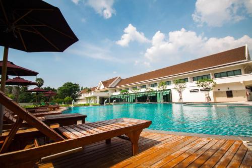 邦盛Bangsaen Heritage Hotel - SHA Plus Certified的一个带长椅和遮阳伞的大型游泳池