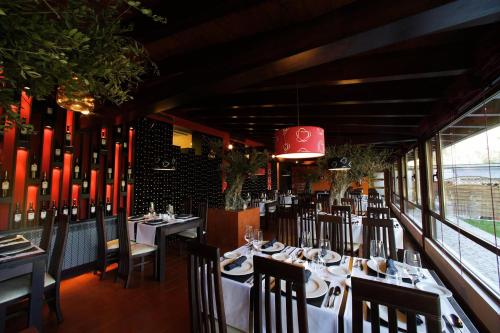埃尔蓬特因苏拉皇家旅馆的餐厅设有桌椅和红色吊灯。