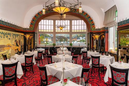 特拉本特拉巴赫贝勒沃罗曼蒂克乔根德斯特酒店的餐厅配有白色的桌椅和吊灯