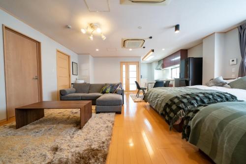 神户HOTEL er.的一间带两张床的卧室和一间带沙发的客厅