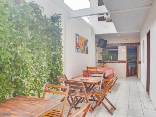 福塔莱萨Pousada Pepone - Fortaleza Centro的一个带桌椅的庭院和绿色的墙壁