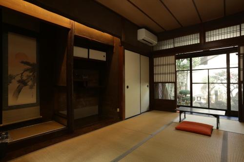 京都Guesthouse KYOTO COMPASS的一个空房间,有长凳和窗户