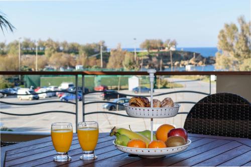 加藤-达拉特索Xenios Dias Luxury Apartments With Sea View的一张桌子,上面放有水果和两杯橙汁