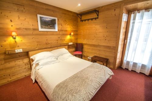 VerchaixApartment Jazz - La Terrasse de Verchaix的卧室配有木墙内的一张床