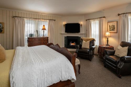 杰克逊荆棘山酒店的一间卧室配有一张床和椅子,以及一个壁炉