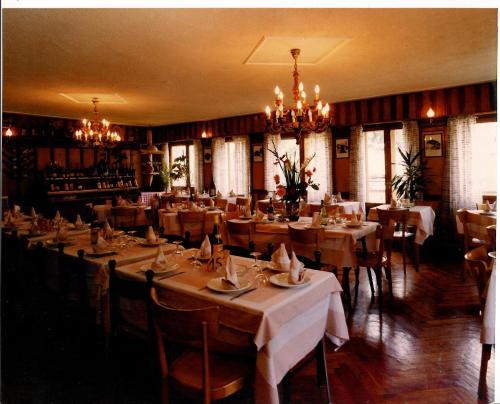 埃特鲁布莱斯宝瑟约尔酒店的一间带桌椅和吊灯的餐厅
