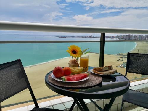 福塔莱萨Modern Beachfront Apartment w. Magnificent Seaview的一张桌子上的水果盘,享有海滩美景