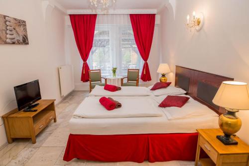 利托梅日采木屋酒店的一间卧室配有两张带红色枕头的床