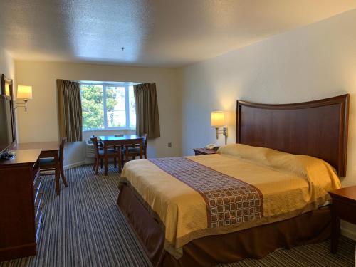 南旧金山机场旅馆的酒店客房配有一张床铺和一张桌子。