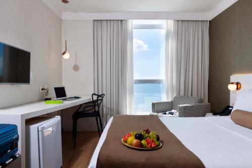 维多利亚维多利亚码头酒店的一间酒店客房,床上放着一碗水果
