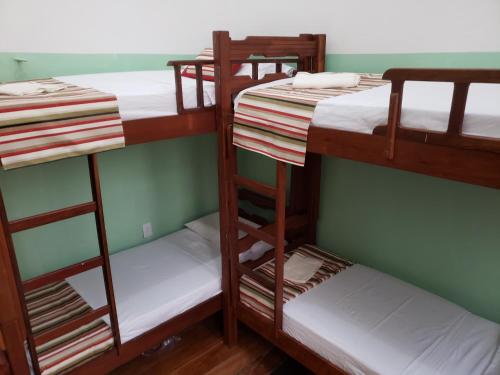 贝伦Antonieta Hostel的客房设有三张双层床,配有白色床单