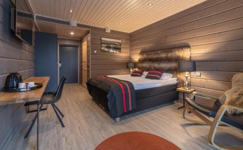 伊纳利Wilderness Hotel Inari & Igloos的一间卧室配有一张床、一张桌子和一把椅子