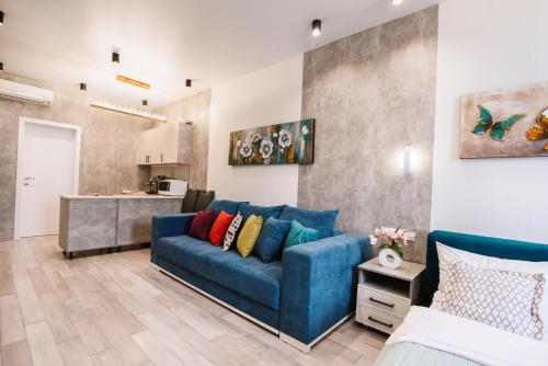 基辅Royal Tower Luxurious Smart Residence (1)的一间带蓝色沙发的客厅和一间厨房