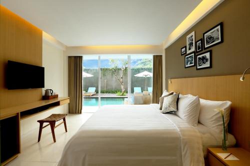 勒吉安勒吉安奥索特尔酒店的一间卧室配有一张床、一台电视和一个游泳池