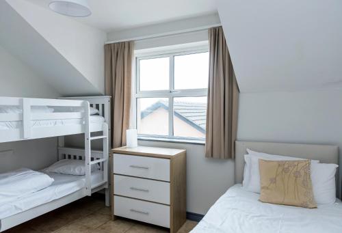 班多伦Marine Court的一间卧室设有两张双层床和一扇窗户。