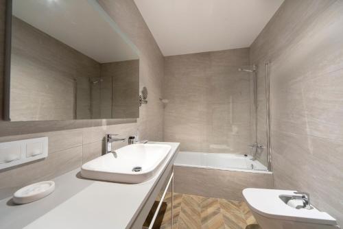 塞哥维亚Real Segovia Apartments by Recordis Hotels的浴室配有盥洗盆、卫生间和浴缸。