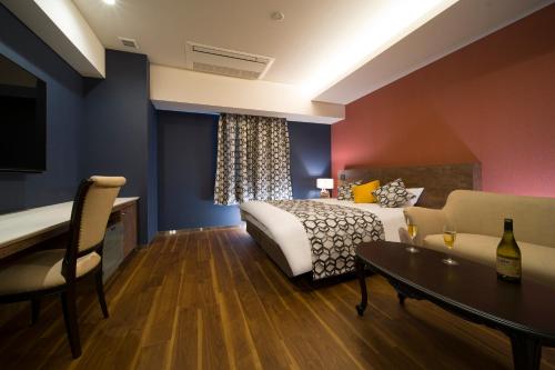 和歌山HOTEL LASCALA的一间卧室配有一张床、一张桌子和一张沙发