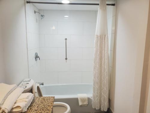 麦迪逊迪尔菲尔德套房酒店 的浴室配有白色浴缸和淋浴。