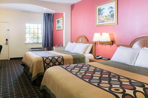 斯塔福德斯塔福德速8汽车旅馆的酒店客房,设有两张床和粉红色的墙壁