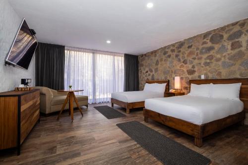 乔卢拉Hotel Boutique Camino Del Bosque by Rotamundos的酒店客房,设有两张床和一张沙发