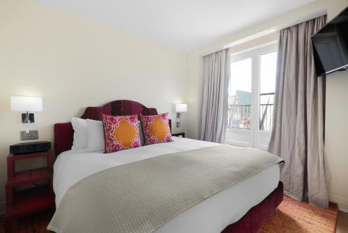 魁北克市圣安东尼酒店的卧室配有带枕头的大床和窗户。