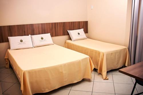 Santa BárbaraImperial Hotel的两张睡床彼此相邻,位于一个房间里