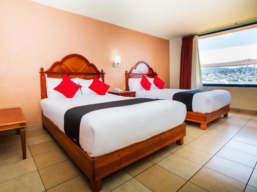 底拉斯卡拉Hotel De La Loma的酒店客房设有两张床和窗户。