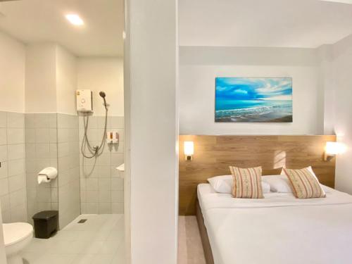 奈扬海滩Pensiri House - SHA Extra Plus的酒店客房配有一张床和淋浴