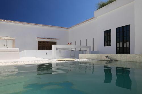 纳布勒达萨布里酒店的一座白色的房子,前面设有一个游泳池