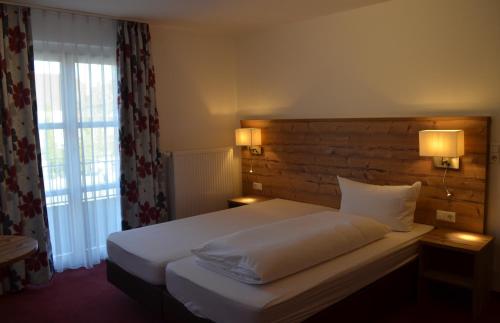 拉施塔特Hotel Zum Goldenen Mann的一间卧室配有一张带两盏灯的床和一扇窗户。