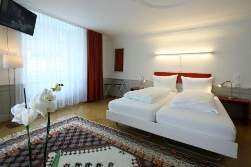 索洛图恩罗特尔奥克森酒店的一间卧室设有两张床和大窗户
