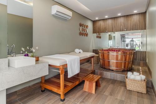 卡鲁阿鲁Citi Hotel Premium Caruaru的浴室配有水槽和浴缸。